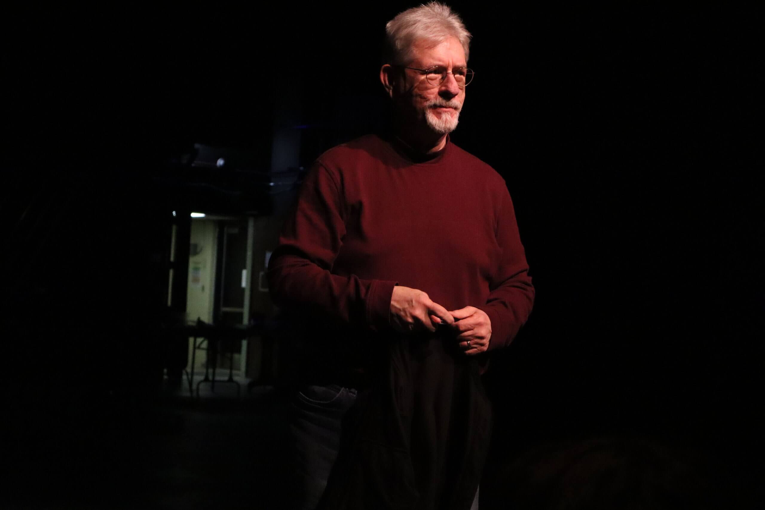 Jerry Casper, February 20, 2026 in a red sweater against a black backdrop