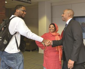 President Jeffrey Boyd shaking hands with male student
