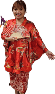 Woman wearing a red silk kimono robe holding an open fan in front of her.